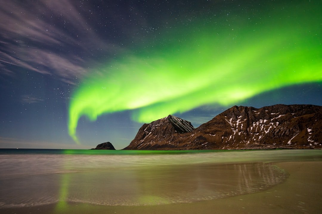 Haukland Beach under northern lights with mirror-wet sand, Lofoten, Norway