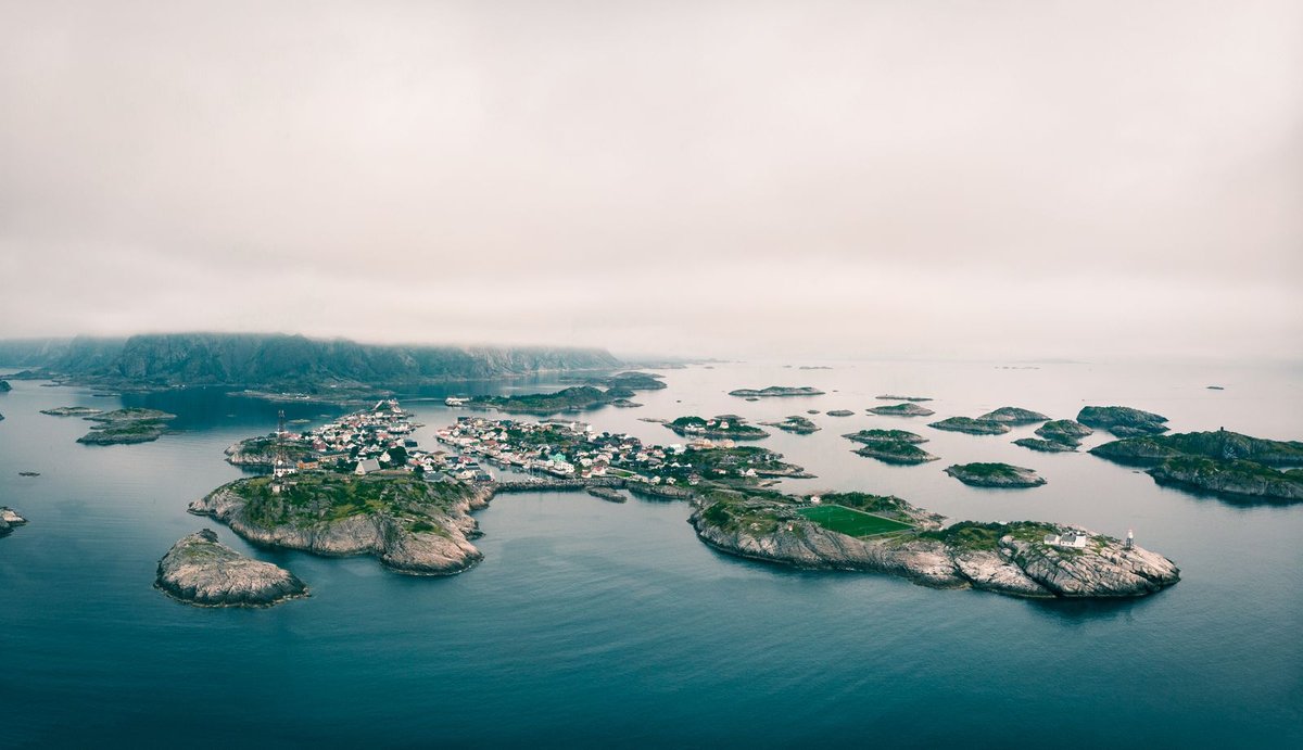 Aerial view of Henningsvaer football pitch surrounded by ocean and mountains, Lofoten