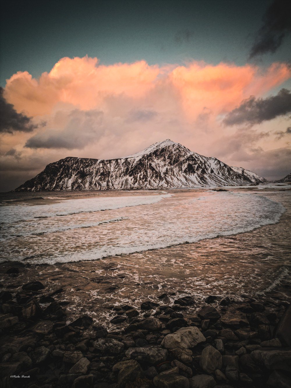 Skagsanden beach surf lines at sunset with Hustinden mountain across the bay, Lofoten