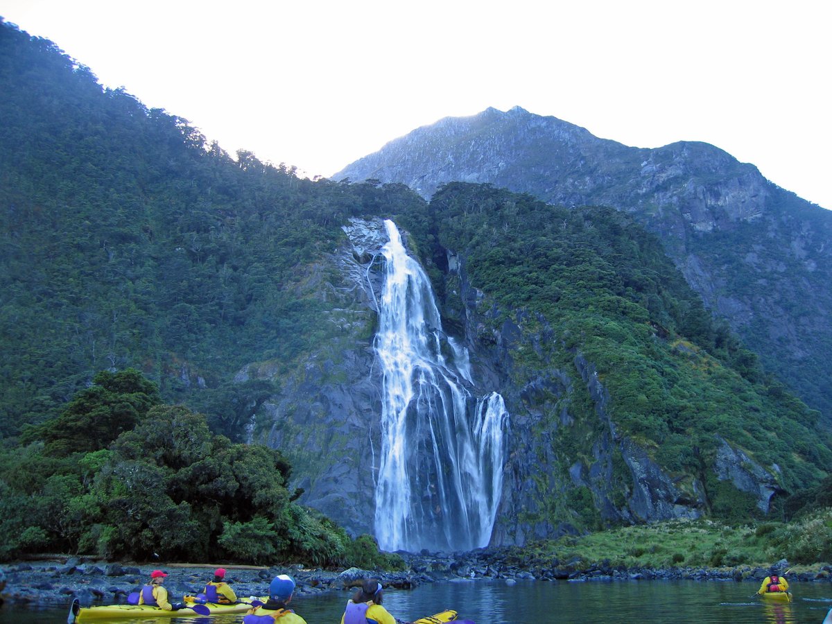 A waterfall pouring down the sheer rock walls of Milford Sound in Fiordland National Park