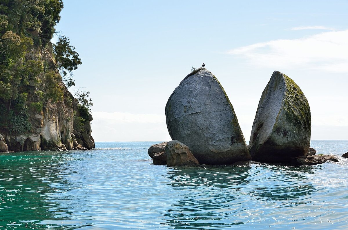 The Split Apple Rock, a granite boulder cleaved in two, sitting in turquoise water off the Abel Tasman coast