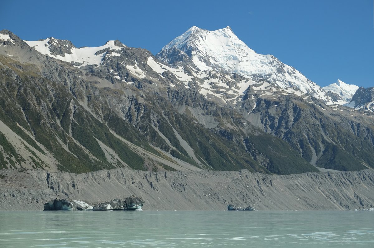 Icebergs floating in the grey meltwater of Tasman Lake below Aoraki/Mount Cook